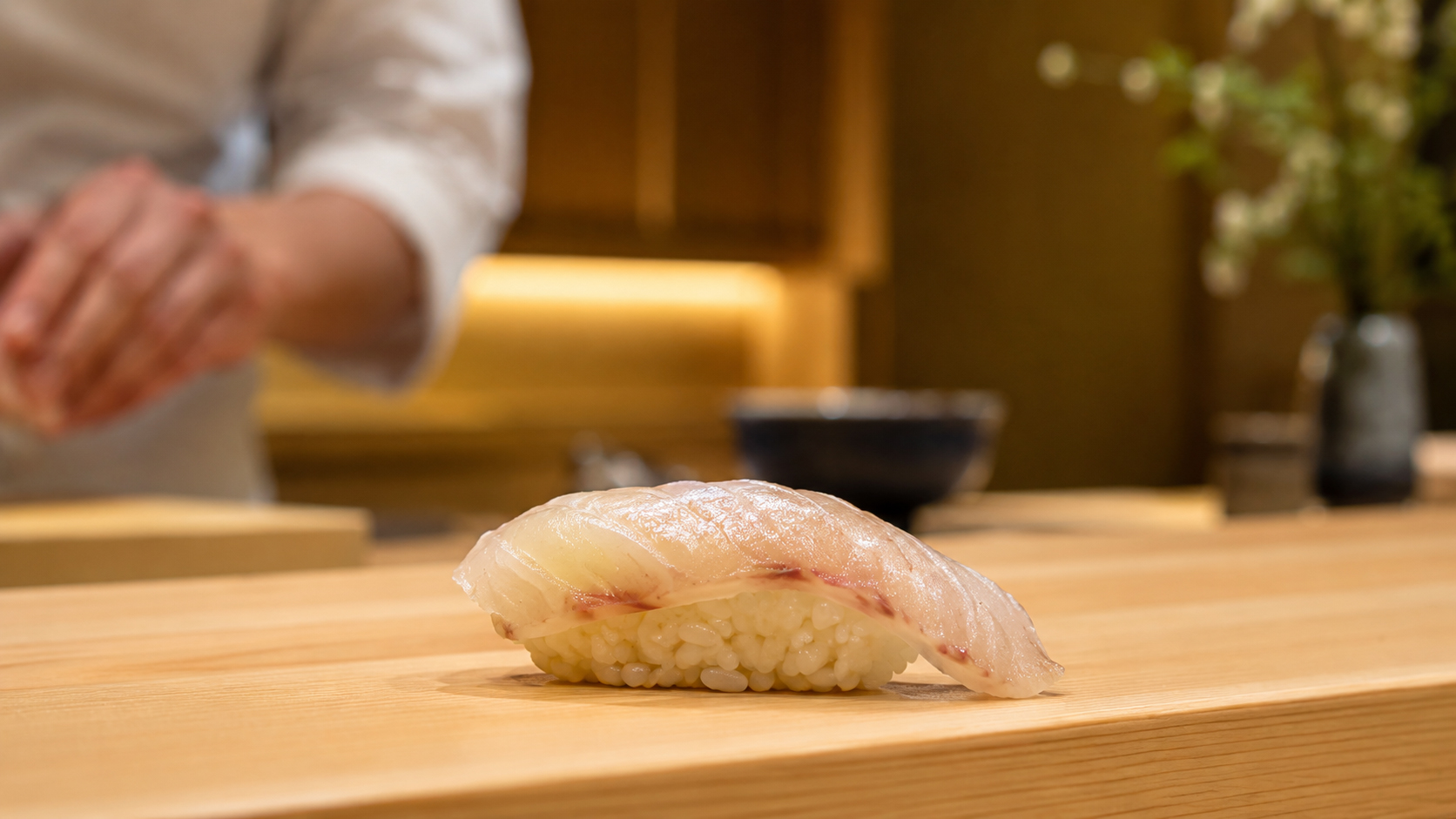 白身魚の握り寿司が静かに置かれたカウンター