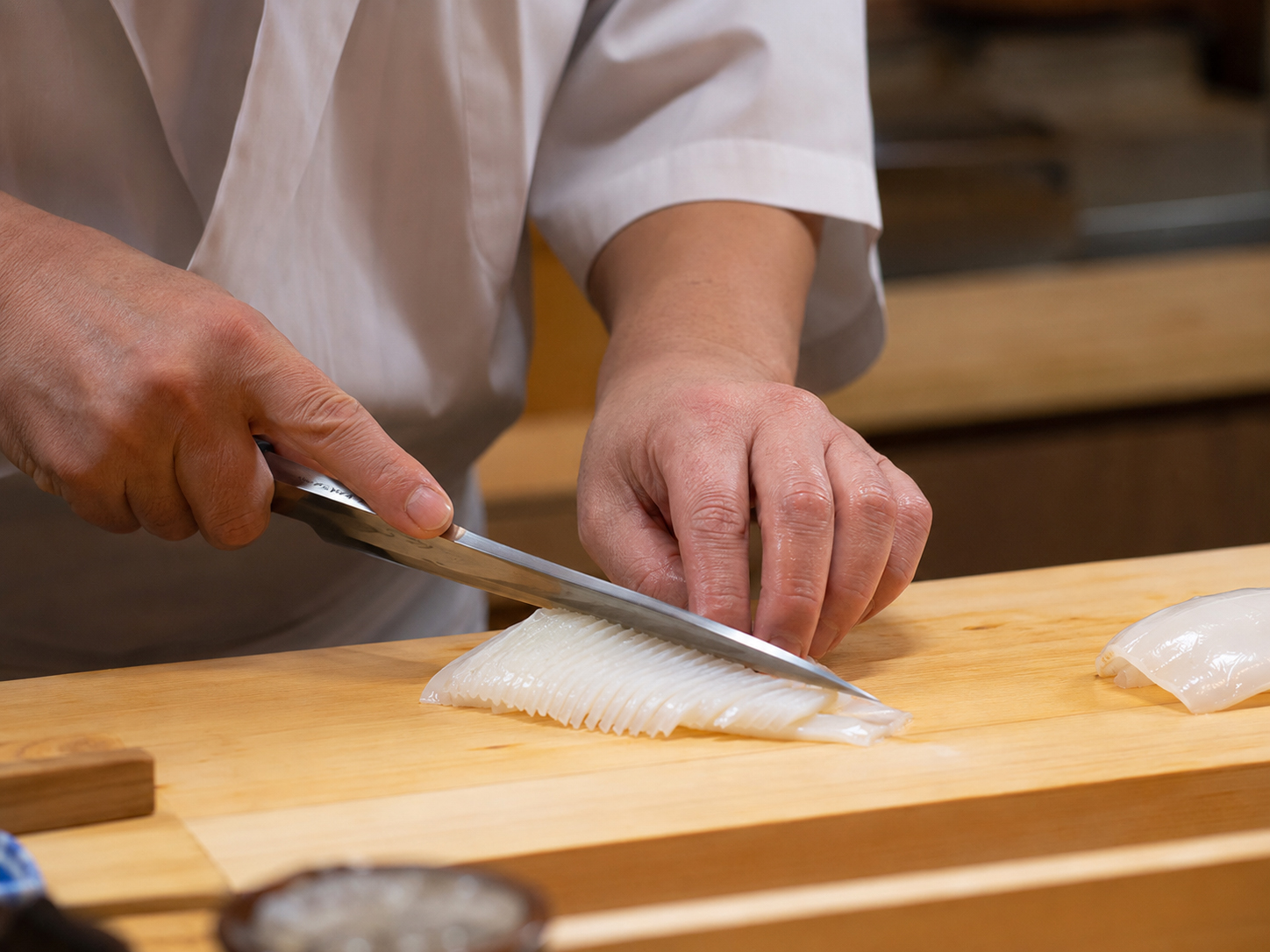 いかに細かな隠し包丁を入れる寿司職人の手元